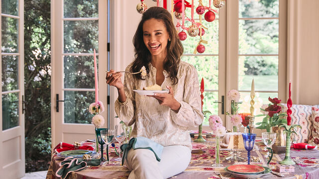 Model in sparkly holiday outfit eating cake